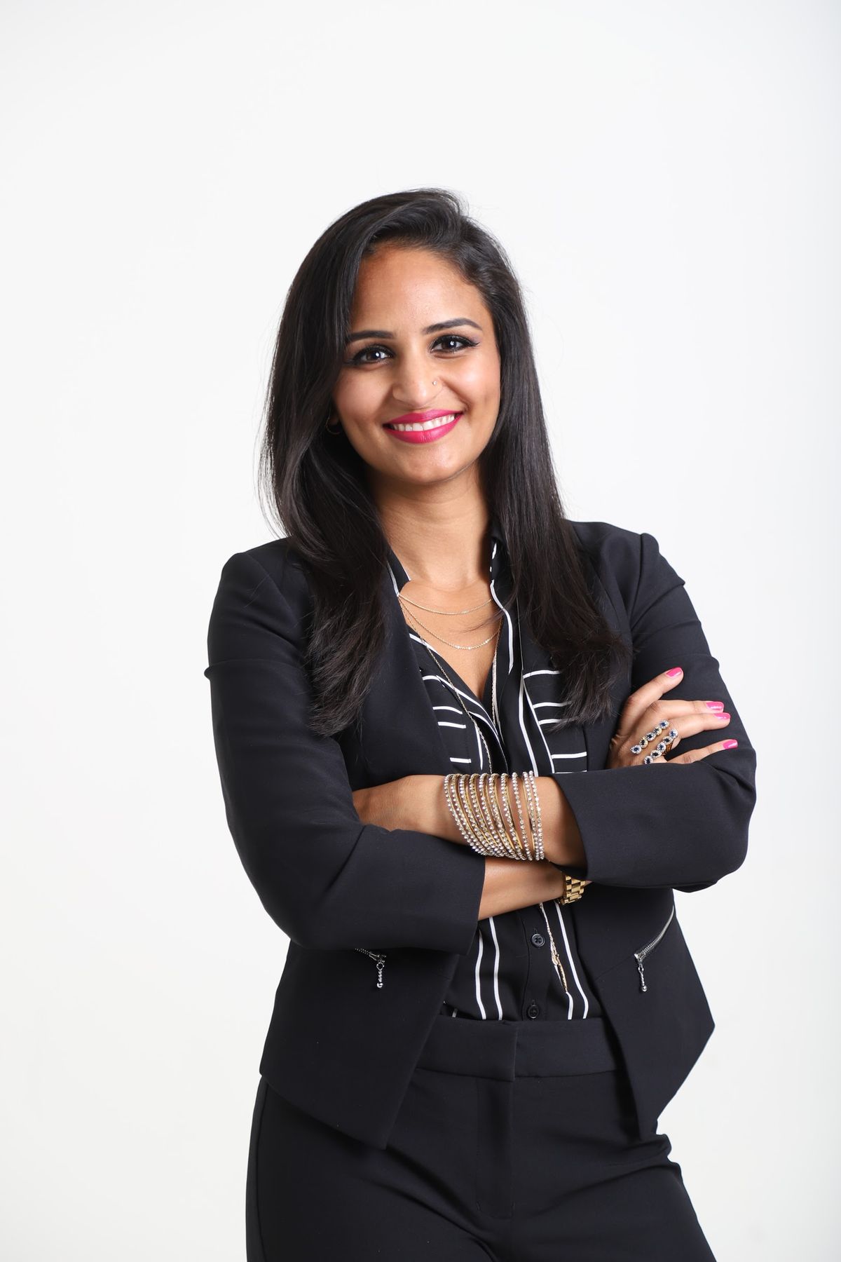 Taniya Refai in a black blazer, smiling with arms crossed